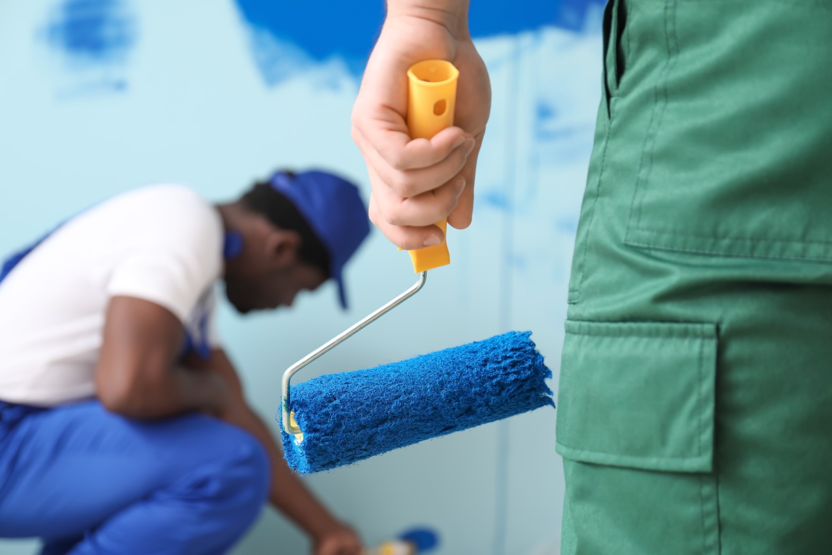 Male painters doing repair in room, closeup